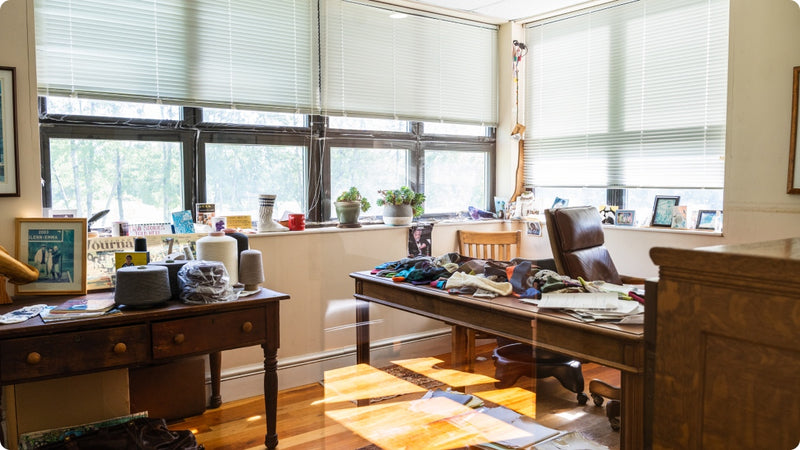 A peak through into Marc's Office, a room with large desks piled high with socks