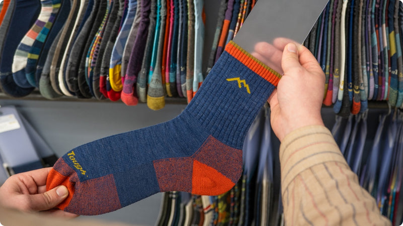 A hand holding one of the golden samples in front of a row of them - these are perfect socks
