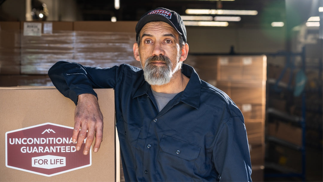 A man standing in front of racks of boxed up socks ready to load on a truck and ship