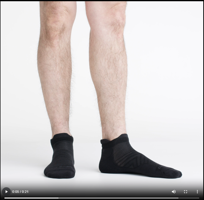 Video of model wearing no show tab running socks in black, showing a 360 degree view of socks.