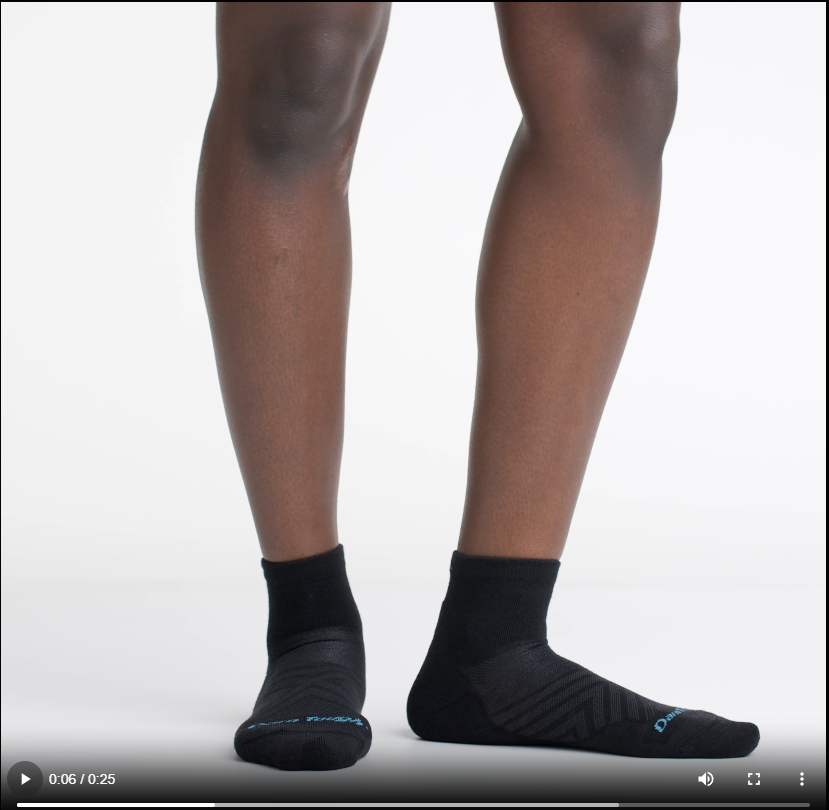 Video of model wearing quarter run socks in black, rotating their feet to show the fit of the socks.