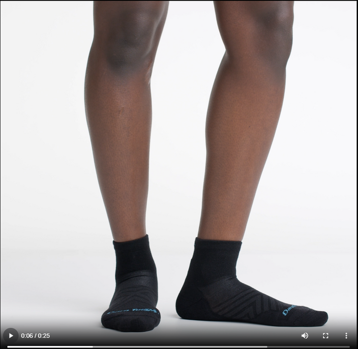 Video of model wearing quarter run socks in black, rotating their feet to show the fit of the socks.
