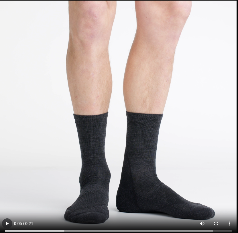 Video of model wearing light hiker socks in black, rotating their feet to show the fit of the socks.