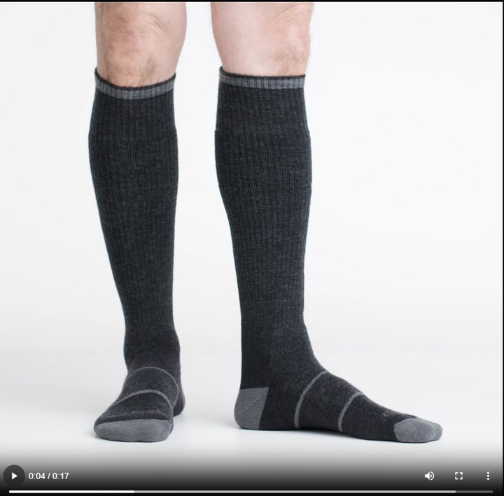 Video of model wearing paul bunyan socks in gravel, rotating their feet to show the fit of the socks.