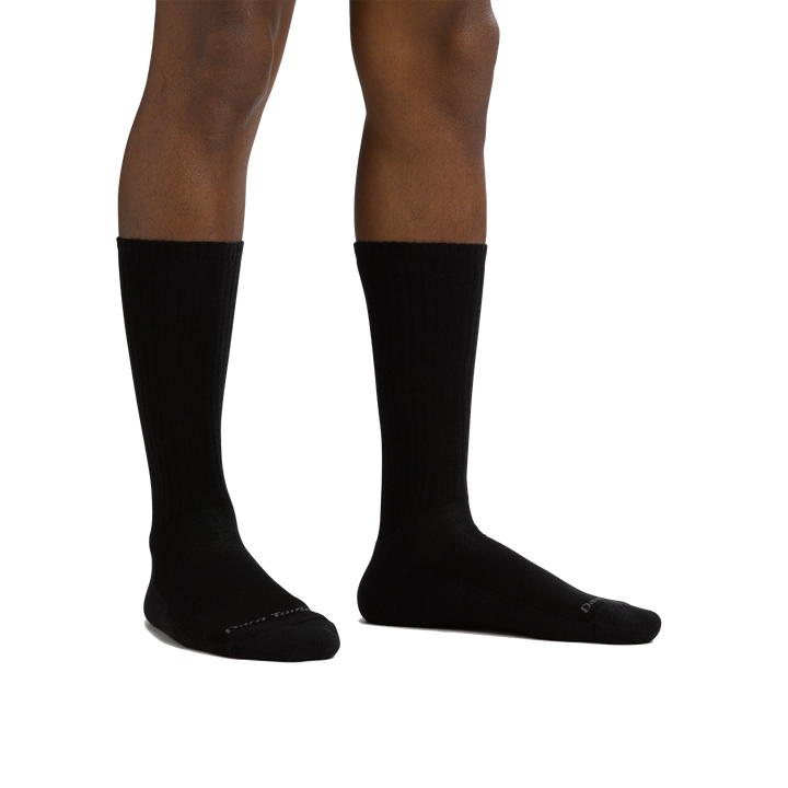 Studio shot of model wearing the men's the standard crew lifestyle sock in black with no shoes on