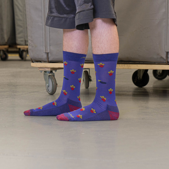 Close up shot of model standing in the nantanna mill wearing the men's beets crew lifestyle sock in eggplant